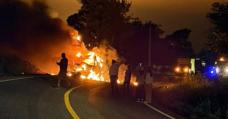 Bomberos apagando camioneta incendiada